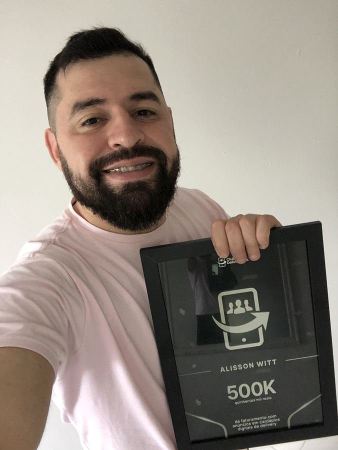 Alisson Witt segurando placa de 500 mil reais faturados para cliente